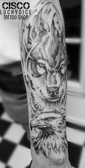 Tatouage d'une tête de loup et une tête d'aigle réalisé par Cisco Lucky Dice Tattoo