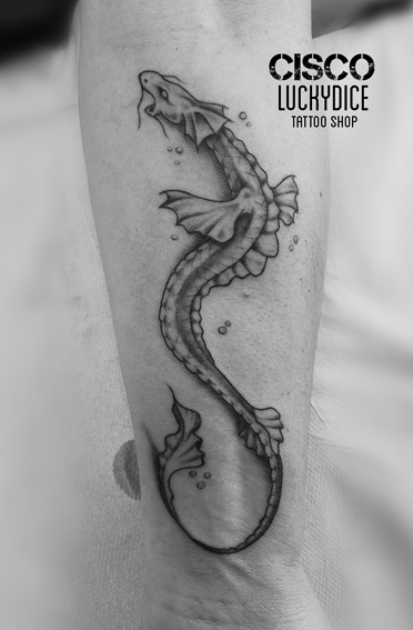 Tatouage d'un petit dragon sur le mollet réalisé par Cisco Lucky Dice Tattoo