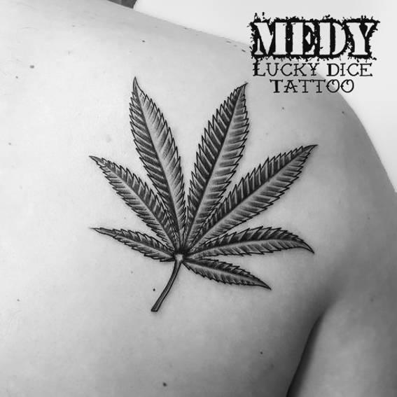Tatouage d'une feuille de cannabis sur un omoplate réalisé par Medy de chez Lucky Dice Tattoo
